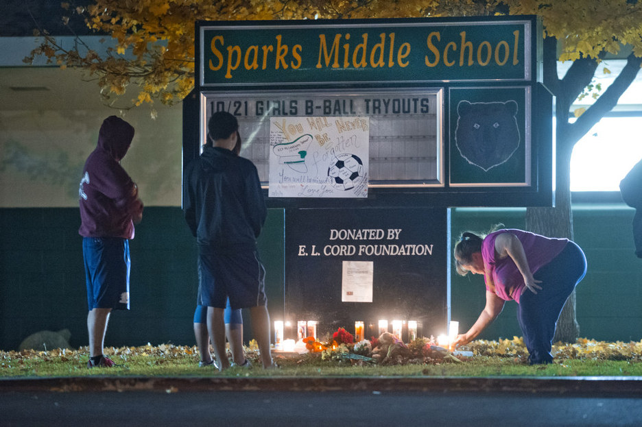 Community members gather to pay their respects to Michael Landsberry, a 45-year-old eighth-grade math teacher, soccer coach and former Marine who was killed by an eighth-grader at Sparks Middle School on Monday, Oct. 21, 2013 in Sparks, Nev. The 12-year-old student who opened fire on the middle school campus, wounding two classmates and killing Landsberry, before he turned the gun on himself, got the weapon from his home, authorities said Tuesday. School District police said they are still working to determine how the boy obtained the 9mm semi-automatic Ruger handgun used in the Monday morning spree at Sparks Middle School. The boy’s parents are cooperating with authorities and could face charges in the case, police said.