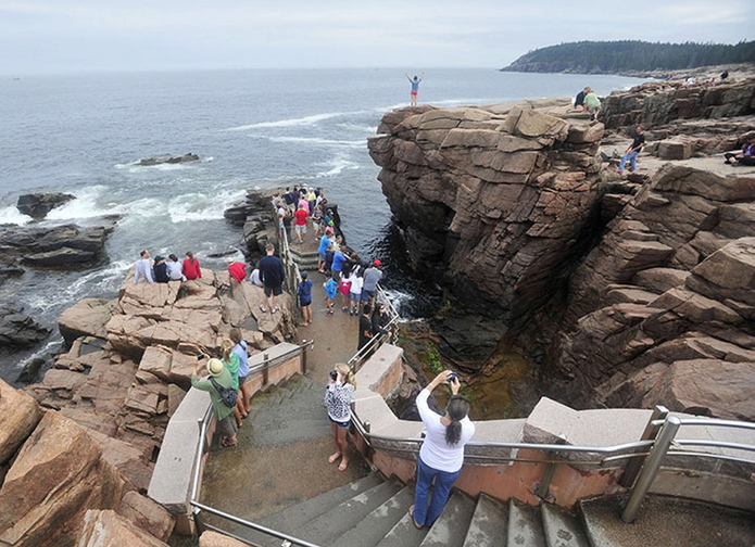 Crowds of people gather around Thunder Hole at Acadia National Park in Bar Harbor in July. Despite the shutdown, the park could be opened if the state has the money to operate it.