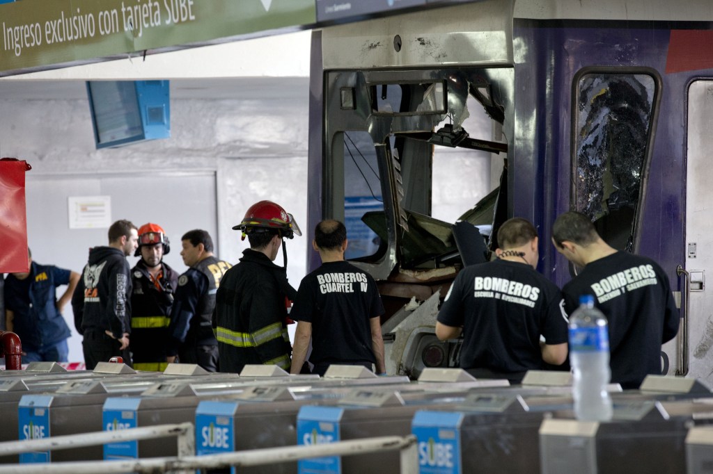 Police and firemen work on a commuter train that slammed into the end of the line when arriving to Once central station in Buenos Aires, Argentina, on Saturday. Emergency officials said at least 80 people are injured, five seriously. Security Secretary Sergio Berni says they are still evacuating the wrecked train and have found no fatalities.