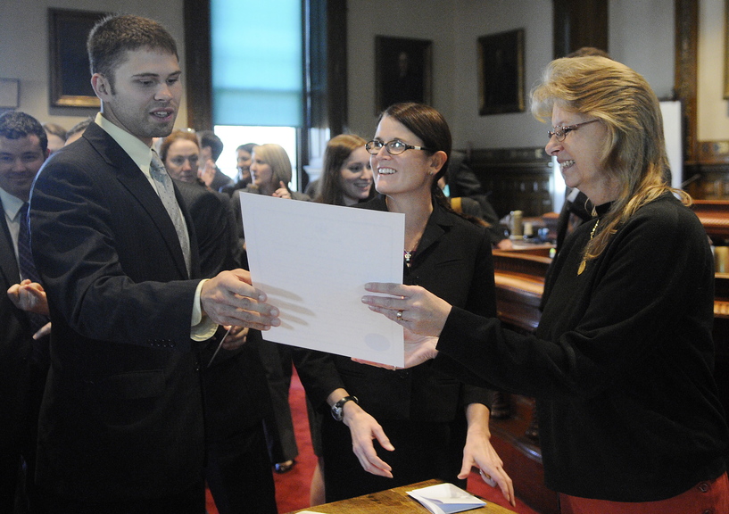 Winthrop native Tavis Hasenfus, left, accepts his certificate of admission to the Maine Bar from Kennebec County Superior Court deputy administrative clerk Penny Moore during a ceremony Monday at the Augusta court for new attorneys practicing in Maine.