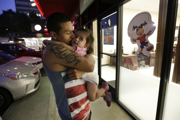 Carlos Rodriguez kisses his 2-year-old daughter, Diana, who relies on the Special Supplemental Nutrition Program for Women, Infants and Children while waiting for his wife outside a WIC offic, in Los Angeles.