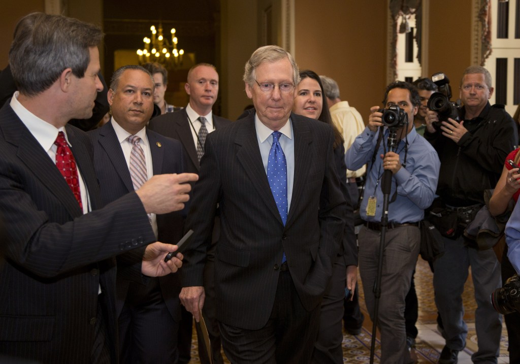 Senate Minority Leader Sen. Mitch McConnell, R-Ky., walks to the Senate floor after agreeing to the framework of a deal to avoid default and reopen the government on Capitol Hill on Wednesday, Oct. 16, 2013 in Washington.