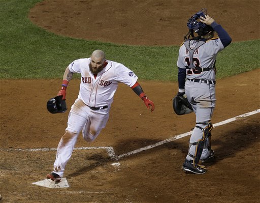 Boston Red Sox's Jonny Gomes scores the winning run on a hit by Jarrod Saltalamacchia during Game 2 of the American League baseball championship series against the Detroit Tigers Sunday, Oct. 13, 2013, in Boston. At right is Detroit Tigers' Alex Avila. (AP Photo/Matt Slocum)