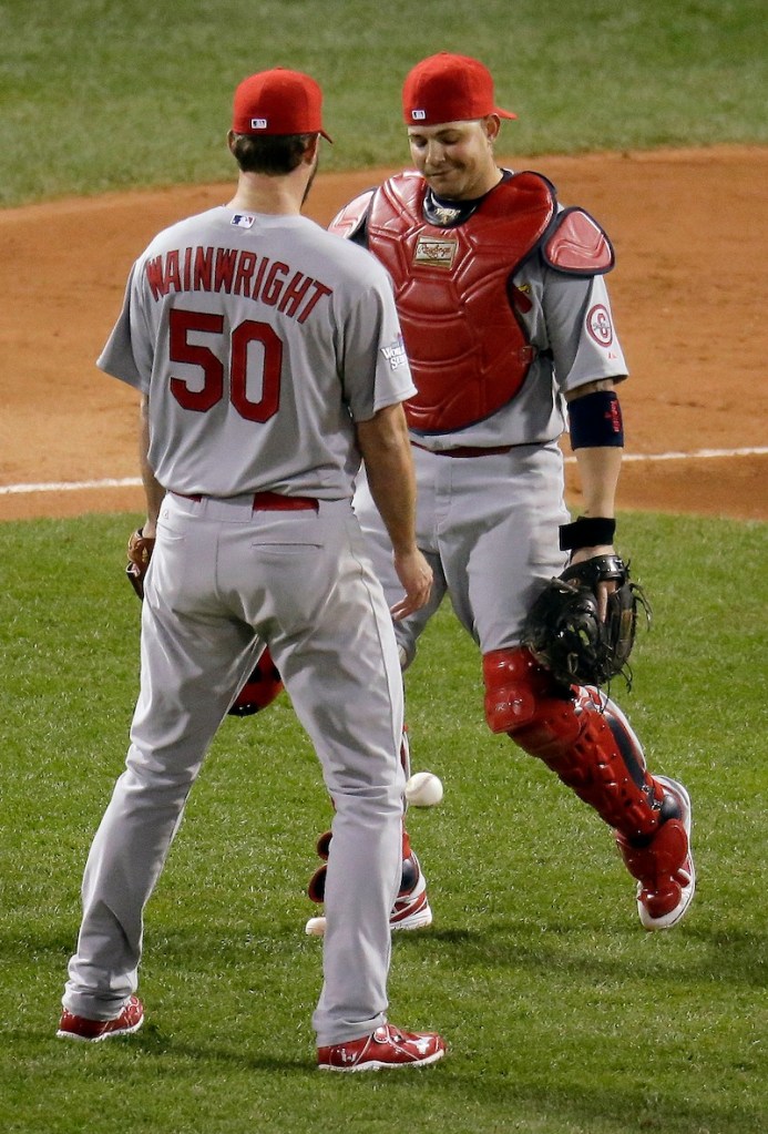 St. Louis Cardinals starting pitcher Adam Wainwright looks at catcher Yadier Molina after neither could catch a pop up by Boston Red Sox's Stephen Drew during the second inning of Game 1 of baseball's World Series Wednesday, Oct. 23, 2013, in Boston. MLB