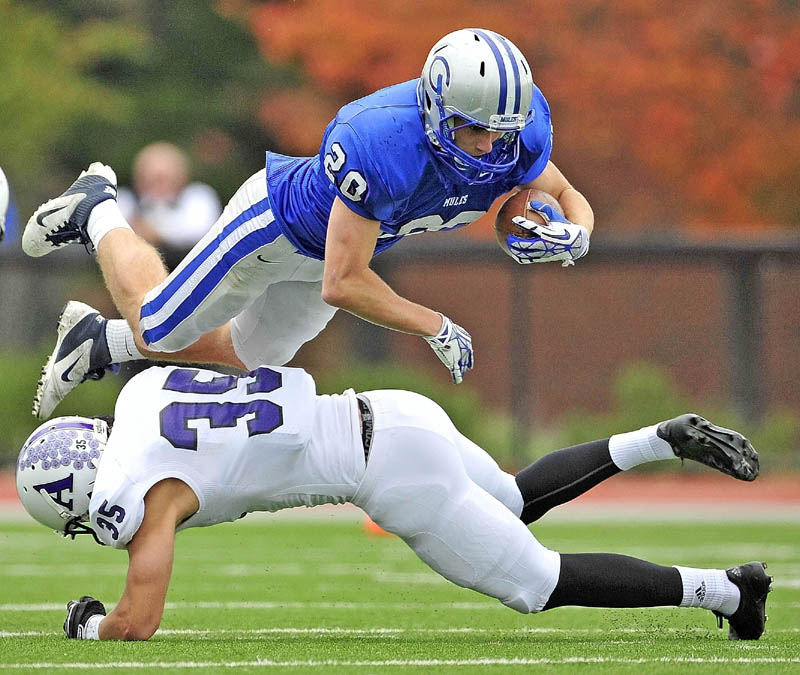 UP AND OVER: Colby College’s Thomas Brewster dives over Amherst College defender Christopher Dow during the Mules’ 14-10 loss Saturday at Colby College in Waterville.