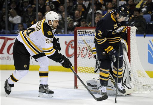 Boston Bruins defenseman Adam McQuaid (54) chases Buffalo Sabres right winger Drew Stafford (21) as he eyes an incoming shot during the first period of an NHL hockey game in Buffalo, N.Y., Wednesday, Oct. 23, 2013. (AP Photo/Gary Wiepert)