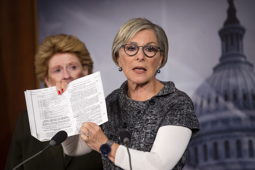 Sen. Barbara Boxer, D-Calif., holds up a passage from the Affordable Care Act concerning health care benefits for women as she tell reporters on Monday that House Republicans’ fight against it is tantamount to a war against women.
