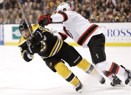 Boston Bruins' Brad Marchand, left, is checked by New Jersey Devils' Marek Zidlicky, of the Czech Republic, during the second period Saturday in Boston.