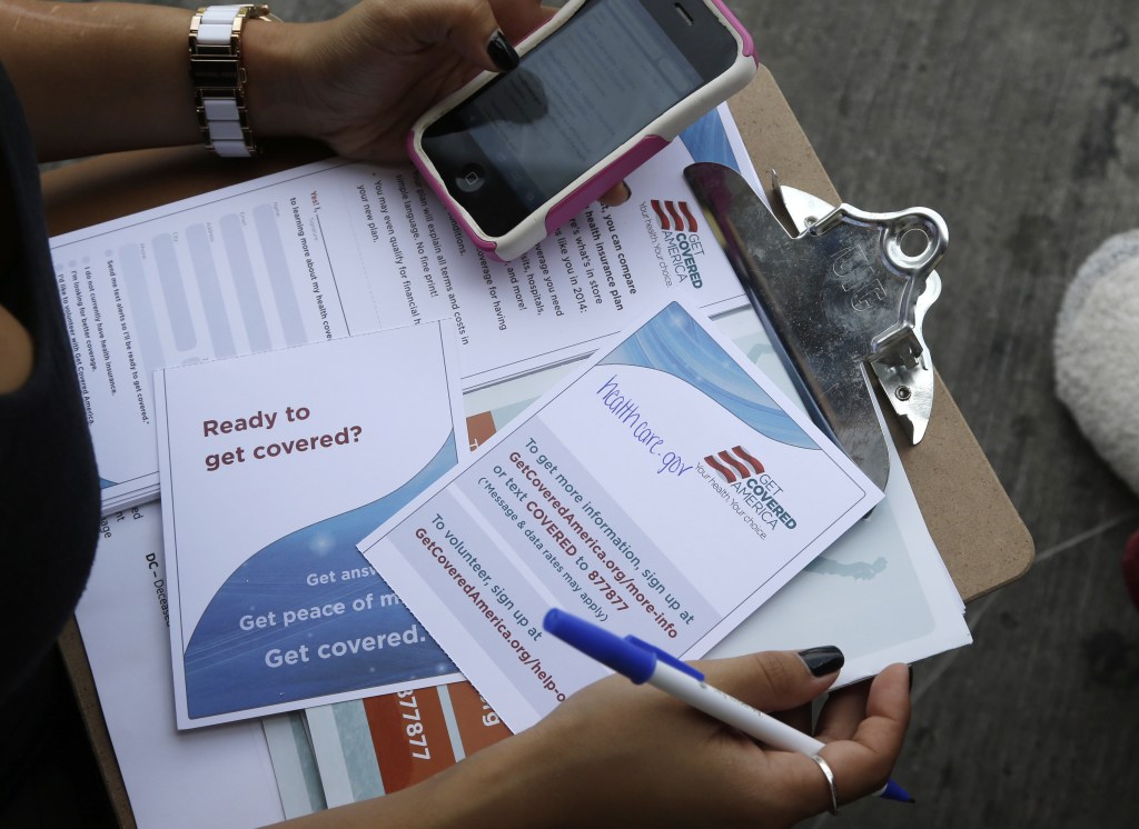 In this Wednesday, Sept. 25, 2013, photo, Maygan Rollins, 22, a field organizer with Enroll America, holds a clipboard with pamphlets while canvassing at a bus stop in Miami. Enroll America is a private, nonprofit organization running a grassroots campaign to encourage people to sign up for health care offered by the Affordable Care Act.