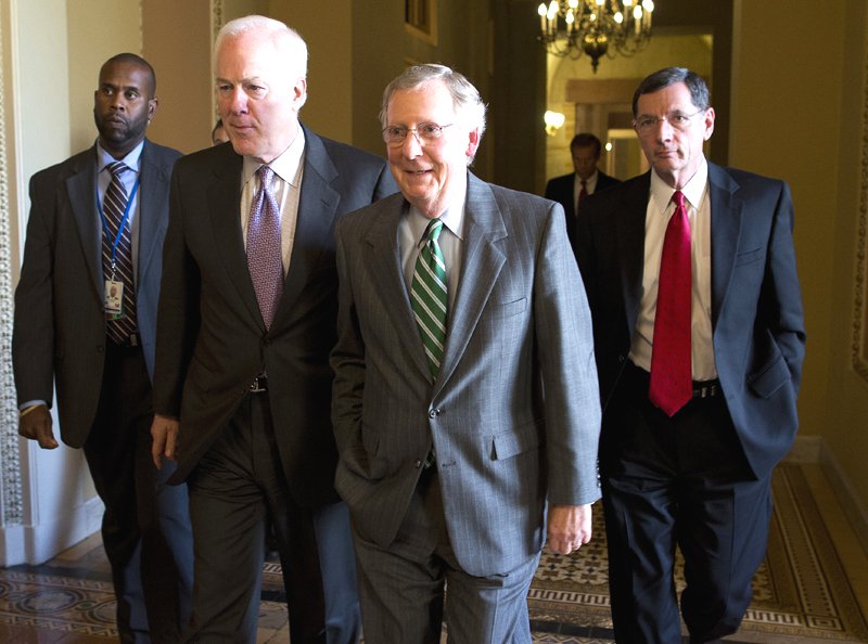 Senate Minority Leader Sen. Mitch McConnell, center, walks with Sen. John Cornyn, left, and Sen. John Barrasso to the Senate floor on Capitol Hill on Monday in Washington.
