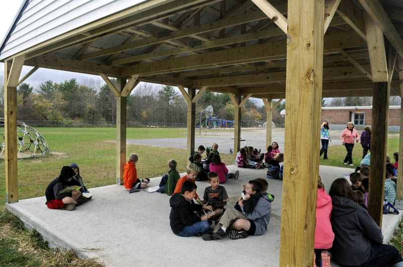 Pittston Consolidated School students read to each other Tuesday under the new outside classroom. Third graders read books to kindergarten students in the structure.