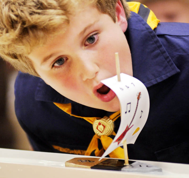 Wolf Scout Ben Nathan, 7, of Hallowell blows his sailboat Thursday during Raingutter Regatta that Cub Scout Pack 6 held in Farmingdale. Over 20 scouts from Hallowell and Farmingdale competed in races with the balsa wood vessels they constructed with six inch masts during the event. Powered by blowing the sail, winners were determined by which boat arrived at the end of a rain gutter first.