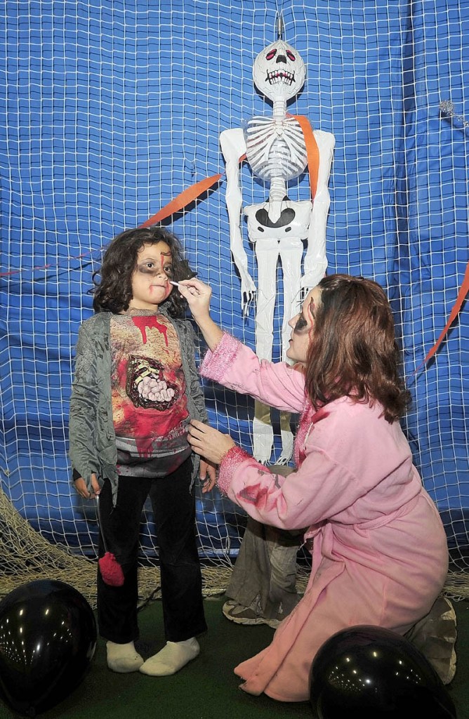 India Hernandez, 6, gets her scars touched up by her mother Dana before the Freaky 5K Fun Run at the Colby College field house organized by Hardy Girls Healthy Women today.