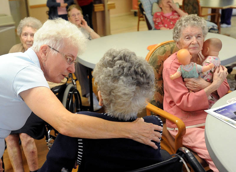 Barbara McCutcheon, left, a recreation assistant at Oak Grove Center in Waterville, speaks with resident Mary Getchell during activity time Friday.