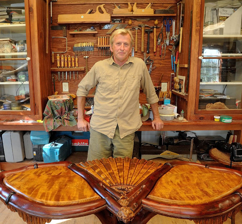 Randy Holden, of Norridgewock, stands in his workshop next to a table he just finished. Holden recently won an award for best artist in woodworking at the Jackson Hole Fall Arts Festival. Holden's business, Elegantly Twisted Rustic Furniture, creates unique furniture using the existing curves and characteristics of the natural wood.
