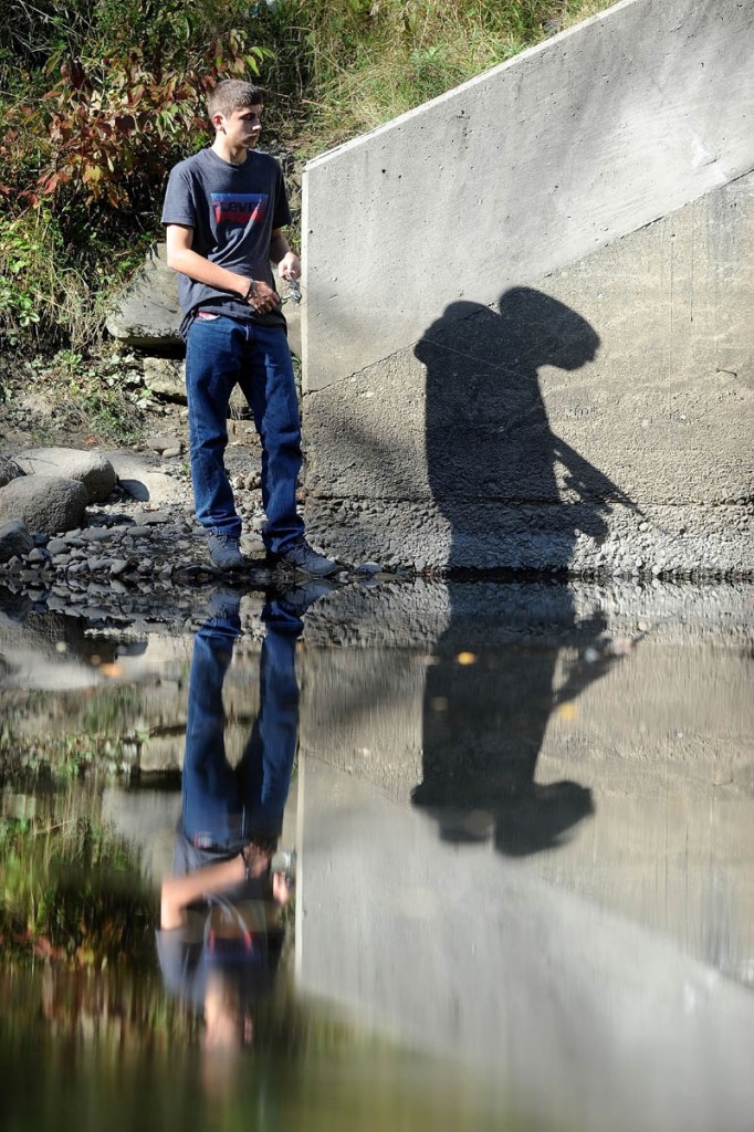 Michael Evans, 16, tries his luck fishing in the summerlike weather on Messalonskee Stream near County Road in Oakland on Sept. 27.