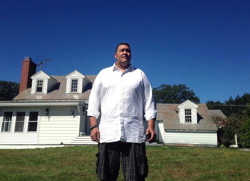 Former NFL offensive lineman Brian Holloway stands in front of his rural vacation home on Sept. 18, 2013, in Stephentown, N.Y. The home was trashed during a Labor Day weekend party attended by an estimated 200 to 400 teenagers.