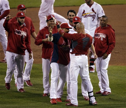 St. Louis Cardinals' Carlos Beltran is congratulated by teammates after his game-winning hit during the 13th inning of Game 1 of the National League baseball championship series against the Los Angeles Dodgers Saturday, Oct. 12, 2013, in St. Louis. (AP Photo/Chris Carlson)