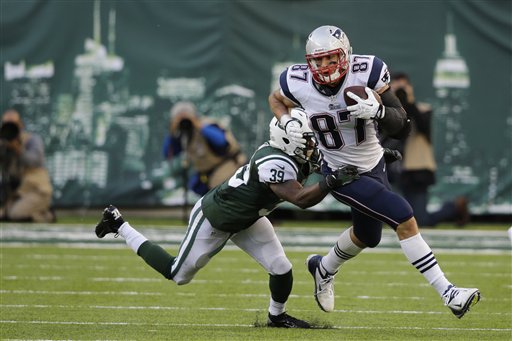 New York Jets' Antonio Allen (39) tackles New England Patriots' Rob Gronkowski during overtime Sunday in East Rutherford, N.J. The Jets won the game 30-27.