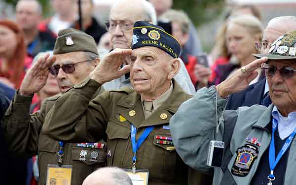 World War II 10th Mountain Division veteran, Charles W. Smith, center, from Plattsburgh, N.Y., salutes with others, during the singing of the National Anthem at the WWII Memorial on Sunday in Washington.