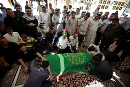 Relatives of a man killed in an attack grieve over his coffin during a funeral in the Shiite holy city of Najaf south of Baghdad on Sept. 22. Two suicide bombers, one in an explosives-laden car and the other on foot, hit a cluster of funeral tents packed with mourning families, killing scores of people during the deadliest of a string of attacks around Iraq.