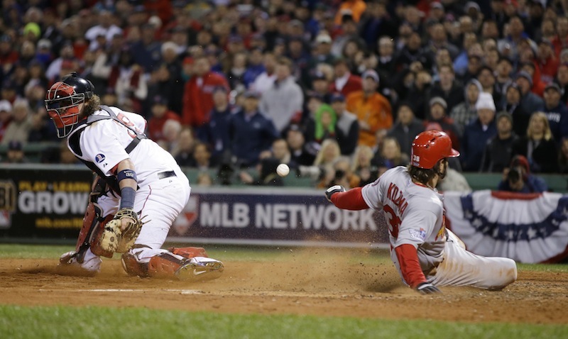 St. Louis Cardinals' Pete Kozma scores on a sacrifice fly as Boston Red Sox catcher Jarrod Saltalamacchia can't handle the throw during the seventh inning of Game 2 of baseball's World Series Thursday, Oct. 24, 2013, in Boston. MLB