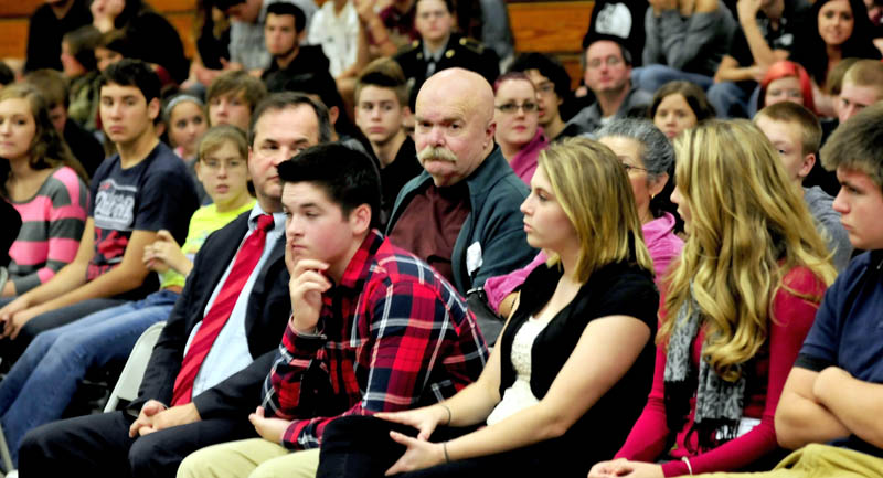 Al Althenn, center, of China, looks at Nokomis Regional High School student Katie Manzo, at right of Althenn, as she asks questions during a break in hearings at the Newport school with Justices of the Maine Supreme Court on Tuesday.