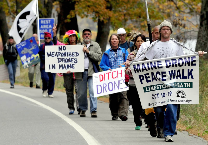 Anti-drone technology marchers led by Jason Rawn, front, make their way through Skowhegan along Route 2 on Sunday. Organizer Bruce Gagnon of Veterans for Peace holds his sign at center.
