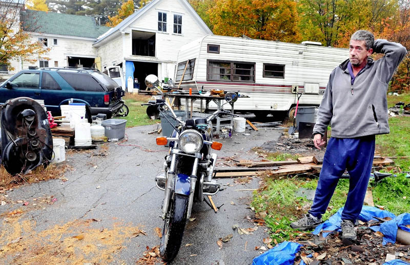 Homeowner Duane Pollis speaks outside his home on Adams Street in Wilton on Monday. Town officials say the home, numerous vehicles and piles of salvaged building materials violates a town ordinance. Wilton is imposing a $100 per day fine until the home is compliance.