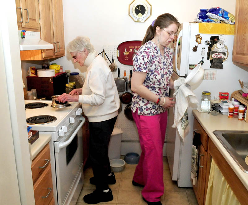 Seton Village resident Marie Rouleau, left, and Personal Support Specialist Zandra Luce work in the kitchen preparing a meal on March 25. Rouleau was among those on a waiting list for the Meals on Wheels program, which restored full service on Tuesday, according to program officials.