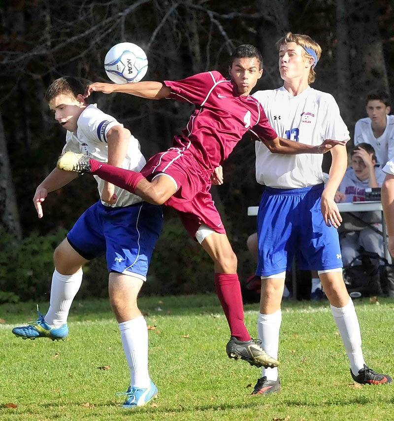 KICKING THE BALL: Messalonskee’s Ryan Erskine, left, and Dylan Burton, right, defend against Bangor’s Eli Clein during the Eagles 2-1 loss Tuesday in Oakland. Burton later scored a goal off an assist from Erskine for Messalonskee.