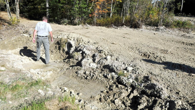 Tom Moore, former trailmaster for the Abnaki Sno-Riders club, inspects a culvert on a spur off the ITS 87 trail in Madison that a neighbor created. Moore said additional volunteer help is needed to maintain area trails, which is currently performed by a handful of members.