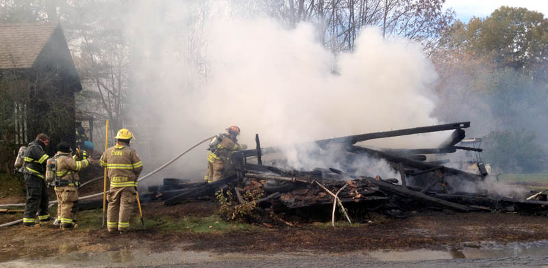 Firefighters from area departments extinguish a building fire that is considered suspicious on the South Reynolds Road in Winslow on Wednesday.