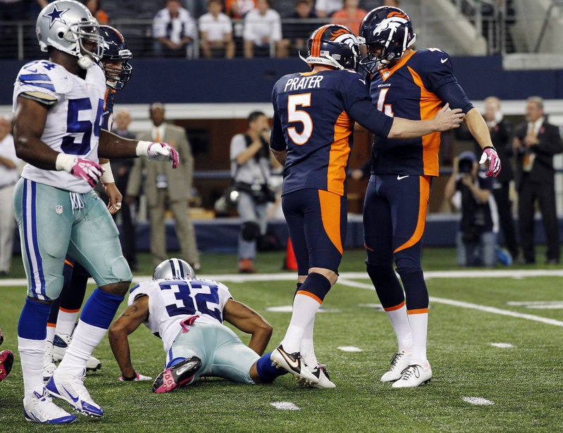 Broncos kicker Matt Prater (5) celebrates with Britton Colquitt, right, after Prater’s 28-yard field goal as time expired gave Denver the win.