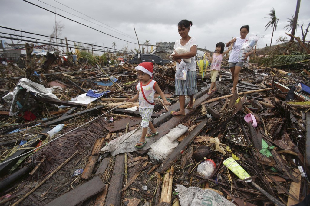Survivors walk in typhoon-ravaged Tacloban city, Leyte province, central Philippines on Tuesday. The Philippines emerged as a rising economic star in Asia but the trail of death and destruction left by Typhoon Haiyan has highlighted a key weakness: fragile infrastructure resulting from decades of neglect and corruption.