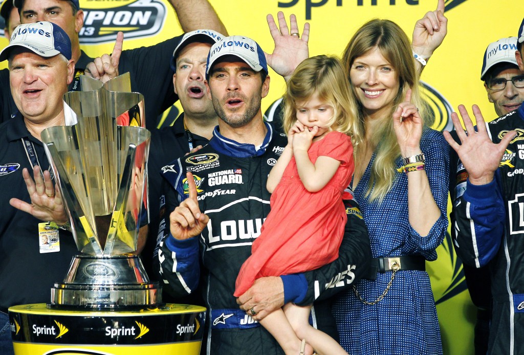 Jimmie Johnson, center, his wife, Chandra, and his daughter, Genevieve, celebrate after he won his sixth NASCAR Sprint Cub Series championship in Homestead, Fla., Sunday, Nov. 17, 2013. (AP Photo/Terry Renna)