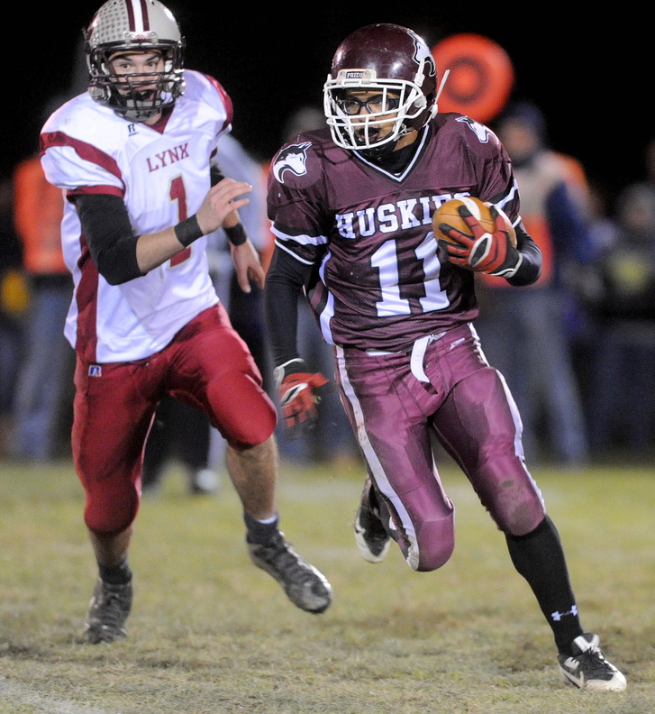 ON THE RUN: Maine Central Institute’s Jonathan Santiago, 11, runs as he is pursued by Mattanawcook Academy’s Trysten Pelky, 1, in the first quarter in Pittsfield on Friday night.