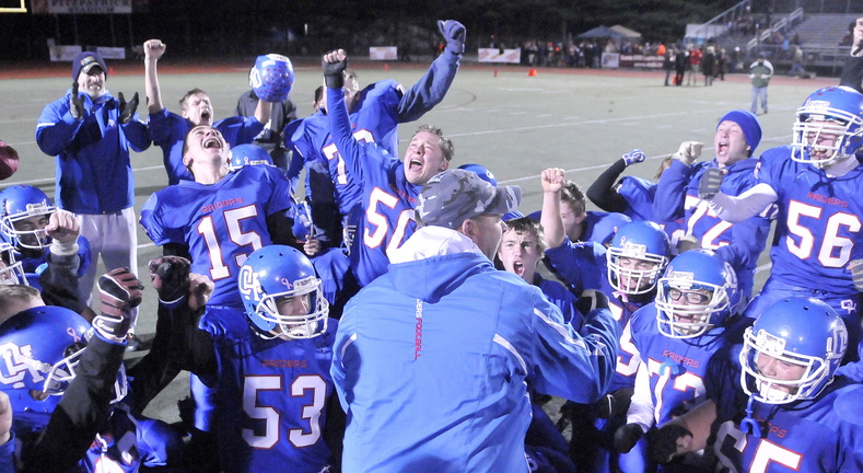 CLASS D FOOTBALL:Oak Hill High School head football coach Stacen Doucette, celebrates with his team after defeating Bucksport High School 42-35 for the Class D championship at Fitzpatrick Stadium in Portland on Saturday.