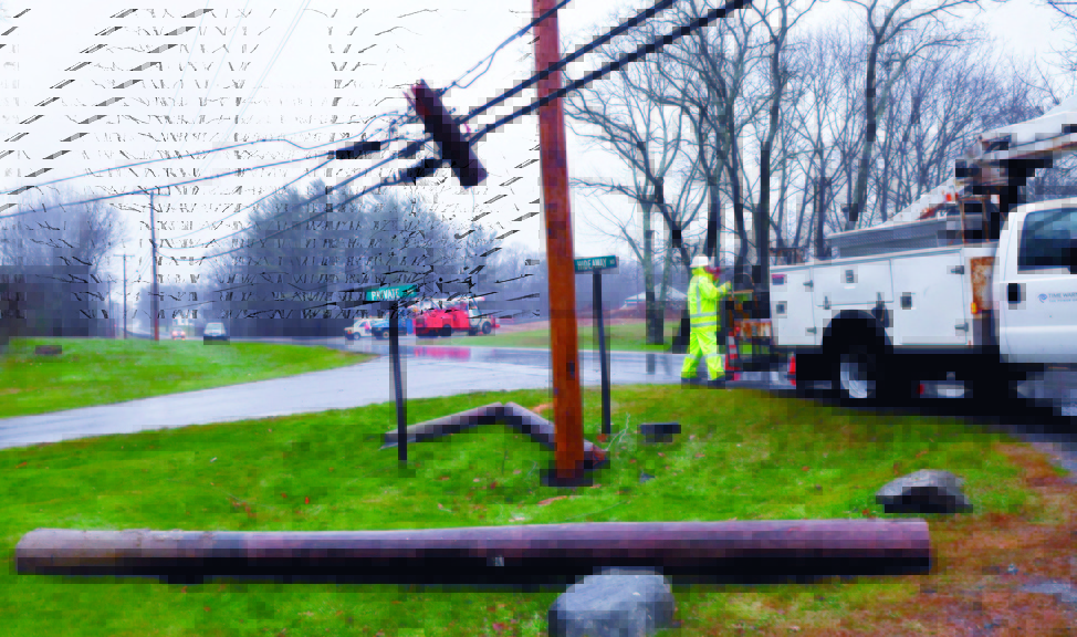 DOWN AND OUT: A Time-Warner company employee prepares to reconnect service to a new utility pole after the pole on ground was broken when a wind-blown tree toppled onto a nearby wire along U.S. Route 202 in Unity on Wednesday. Crews from Unitel and Central Maine Power worked to restore their services after the pole came down about 10:30 a.m. and were finished around 1:45 p.m. Traffic was re-routed around the scene.