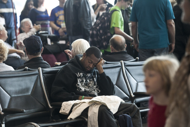 Rashad Simmons of Tampa naps while waiting for his flight at Tampa International Airport on Tuesday in Tampa, Fla. Travelers are facing delays due to winter storms in other areas of the country.