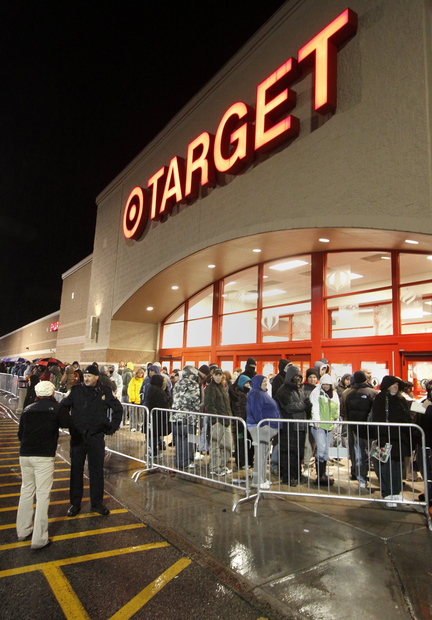 Shoppers wait outside Target in South Portland before the store opened early on Black Friday in 2010. Target, Walmart and Kohl’s are among more than two dozen major chains that have lowered their profit outlooks.