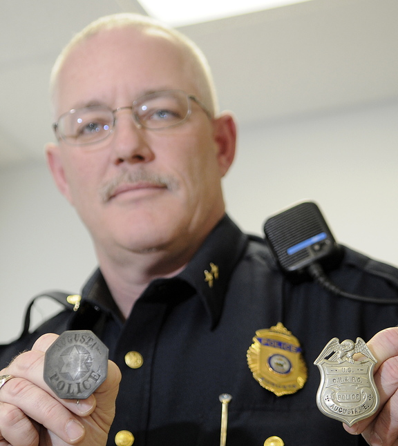 THE BEAT GOES ON: Augusta Police Chief Robert Gregoire holds two badges that belonged to Elbridge Pedder, a Civil War veteran who patrolled the city in the late 19th century. Augusta Police officers are attempting to recover the history of the agency.