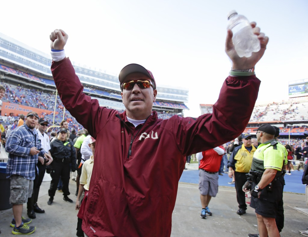 Florida State head coach Jimbo Fisher raises his arm to fans as he comes off the field after defeating Florida 37-7 in Gainesville, Fla., Saturday.