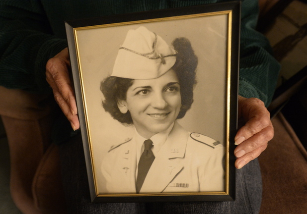 Shawn Patrick Ouellette/Staff Photographer Pauline Young, a nurse in World War II and Korea, holds a photograph of herself in her dress uniform in 1942.