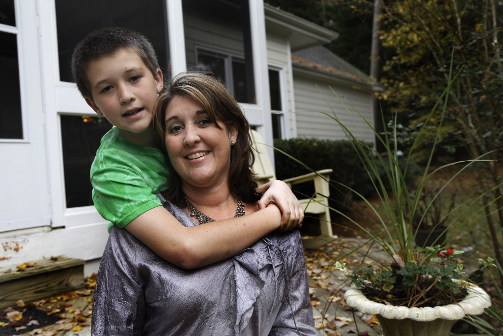 Jill Morin poses for a photo with her son Kyle at their home in Raleigh, N.C. Morin suffers from a serious heart condition and suffered a cardiac arrest in 2009. Morin and hundreds of thousands of other people with pre-existing chronic conditions who are covered through high-risk insurance pools will see their coverage dissolve by year’s end. They are supposed to gain regular coverage under the Affordable Care Act.