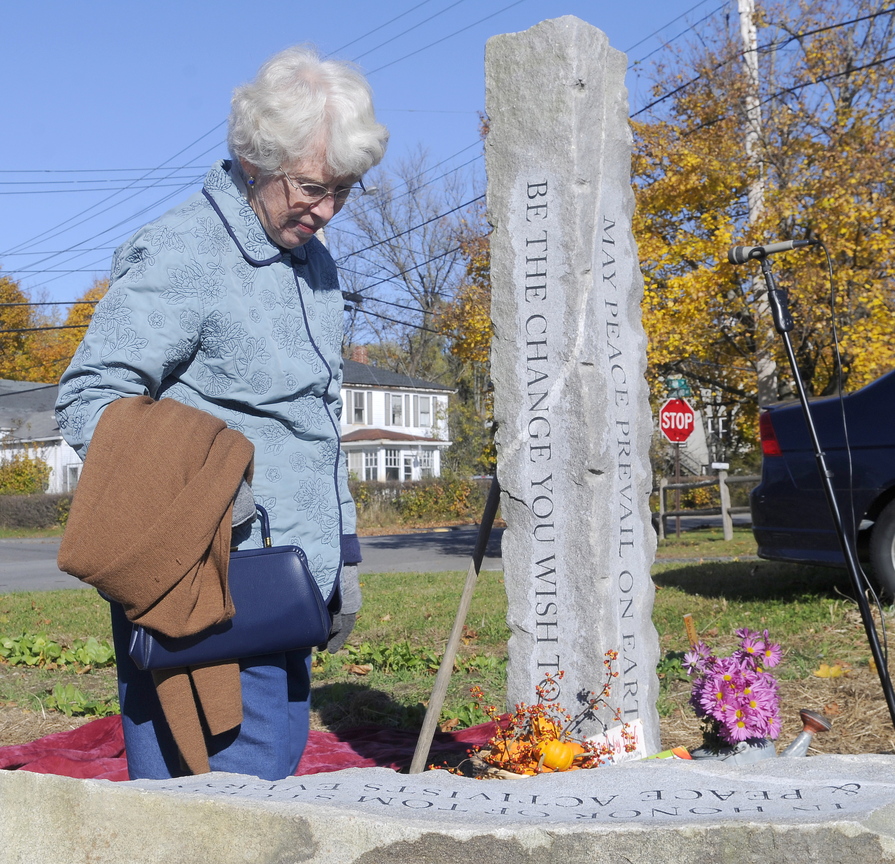 Mary Sturtevant inspects a granite peace pole and bench dedicated in the memory of her late husband, Thomas, on Sunday in Winthrop. A veteran who served in the Navy during the Korean War, Thomas Sturtevant, a former Cony High School teacher, helped found the Maine chapter of Veterans for Peace. The granite peace pole and bench stand in a garden outside the Winthrop Elementary School.