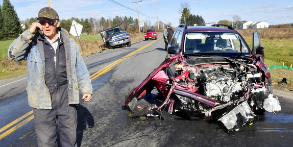 CRASH SCENE: Paul Mushero stands next to an SUV, at right, that struck his truck, in background at left, on Tuesday at the intersection of Route 23 and Rice Rips Road in Oakland.