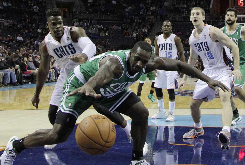 Boston Celtics' Brandon Bass, center, reaches in vain for the ball as Charlotte Bobcats' Jeff Adrien, left, and Charlotte Bobcats center Cody Zeller (40), right, defend during the first half of an NBA basketball game in Charlotte, N.C., Monday, Nov. 25, 2013. (AP Photo/Chuck Burton)