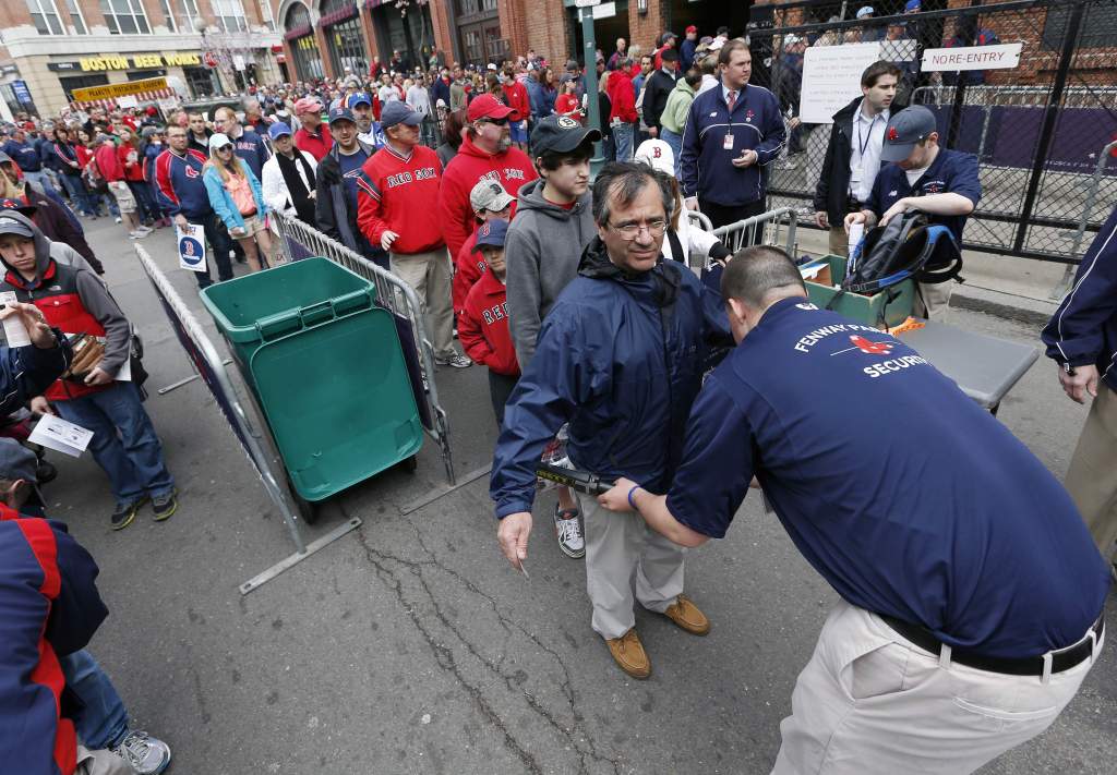 In this April 20, 2013 file photo, fans pass through a security checkpoint before entering Fenway Park for a baseball game between the Boston Red Sox and the Kansas City Royals in Boston. Baseball fans should expect to go through a metal detector to see their team play in 2014. MLB security director John Skinner says at a panel discussion at Harvard that the commissioner’s office plans to recommend walkthrough metal detectors.