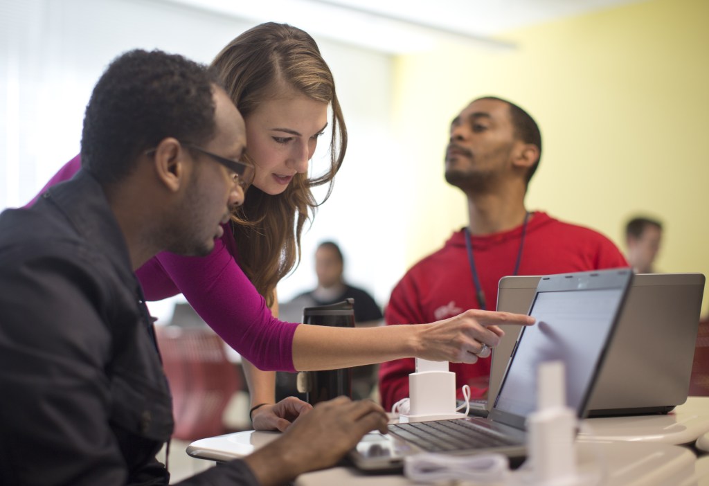 Kaylin Wainwright, center, works with student Natnael Gebremariam, left, at a computer during a General Educational Development test preparation class at the Sonia Gutierrez Campus of the Carlos Rosario International Public Charter School in Washington. Seated right is student Sibusiso Kunene.